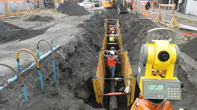 Estación total junto a una zanja con instalación de ductos
