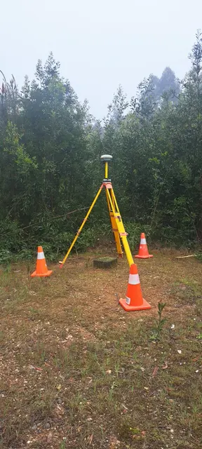 Antena GNSS sobre trípode entre vegetación y conos de seguridad