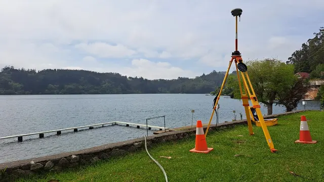 Antena GNSS sobre trípode junto a un muelle flotante