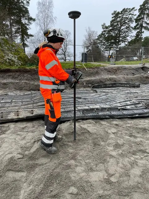 Profesional realizando un levantamiento con antena GNSS sobre un jalón